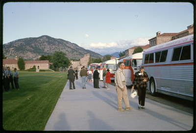 A photographic slide of groups of people leaving a set of busses.