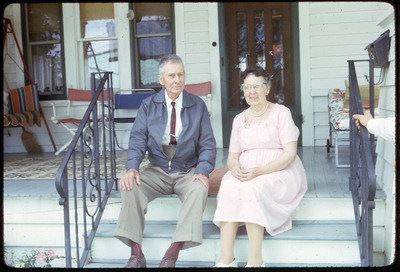 A photographic slide of a man and a woman sitting on the steps of a porch.