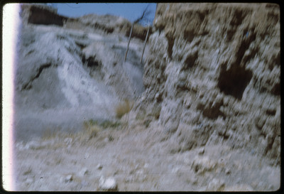 A photographic slide of a blurry view of the side of a rocky cliff.