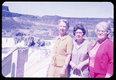 A photographic slide of three women standing in front of a series of waterfalls.