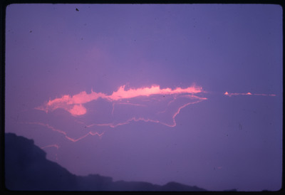 A photographic slide of the center of an active volcano, bubbling with lava and smoke.