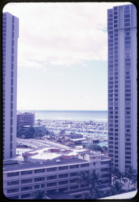 A photographic slide of the view of an oceanside city from a balcony.