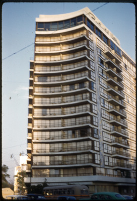 A photographic slide of a tall, curved building.