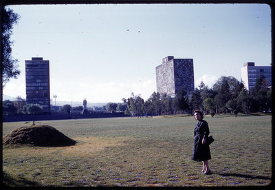 A photographic slide of Evelyn Crabtree standing in the campus of a large building.