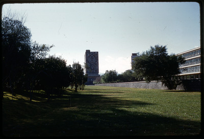 A photographic slide of a grassy campus of a large building decorated with historical art.