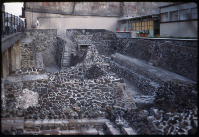 A photographic slide of a stone structure built in a depression in the ground.
