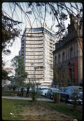 A photographic slide of a tall, curved building.