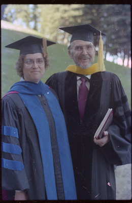 A photo of Donald Crabtree and Ruthann Knudson at graduation at the University of Idaho. Both are wearing caps and gowns.