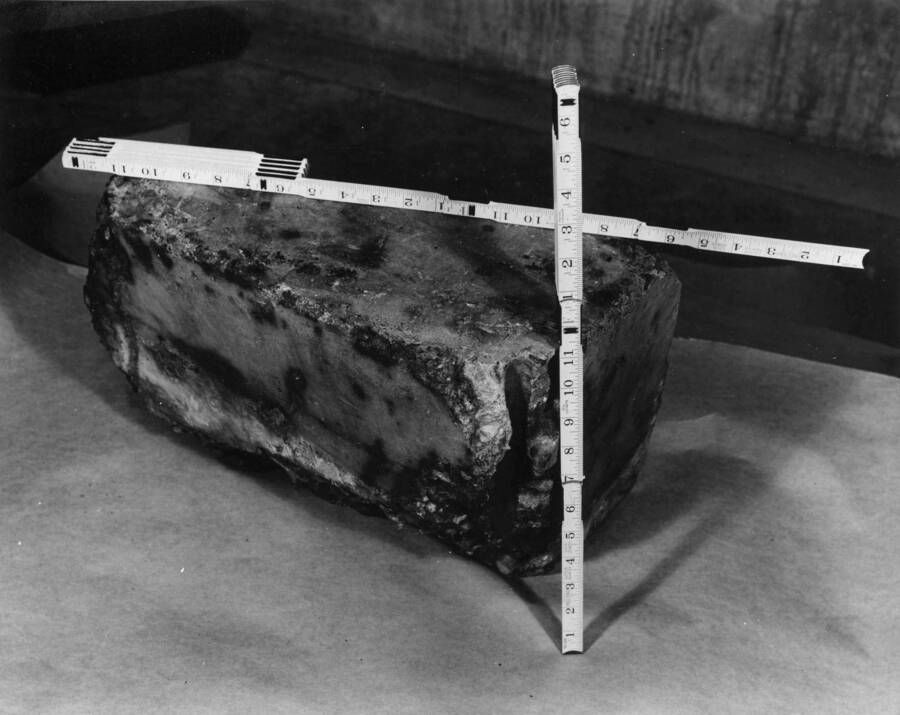96 pound block of concrete found in unit L-4 turbine runner, 3-20-44. The 7/8' diameter hole in the foreground appears to have been an anchor bolt hole. Rectangular dimensions are 17' x 11' while wedge side dimensions are 17' x 10' x3'