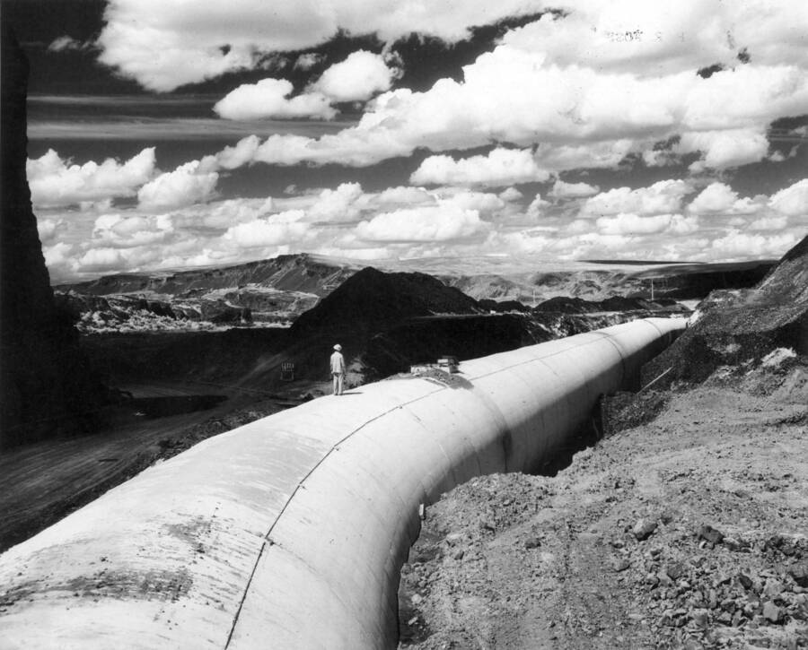 Columbia Basin Project, Irrigation Division, Soap Lake Siphon, Specs. 2411. This photograph taken from concrete section 84A, looking upstream, shows a man on section 82A. Infra-red was used to accentuate the cloud effect. Work is being performed by Winston-Utah under Schedule II of the above specs. H.E. Foss, photographer.