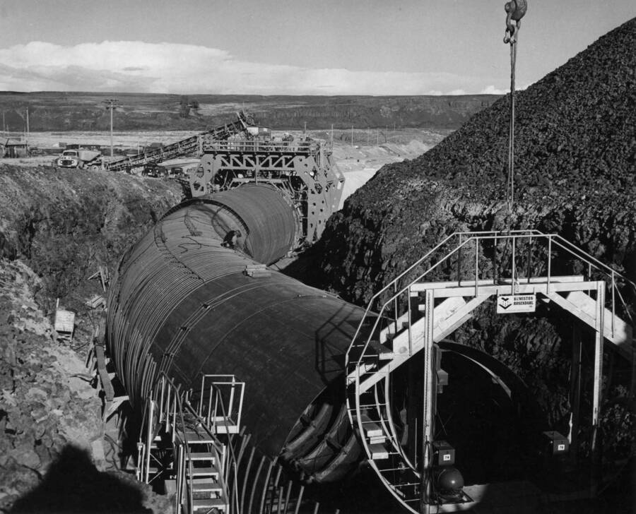Columbia Basin Project, Irrigation Division, Soap Lake Siphon, Specifications No. 2411, Winston Brothers and Utah Construction Co., Contractors. This photograph, looking upstream, of the horizontal curve, P.I. Station 468+54.95. In the foreground are shown two of Humiston-Rosendhal's 'ferris wheels' used in making the field weld joining the liner sections. H.E. Foss, photographer.