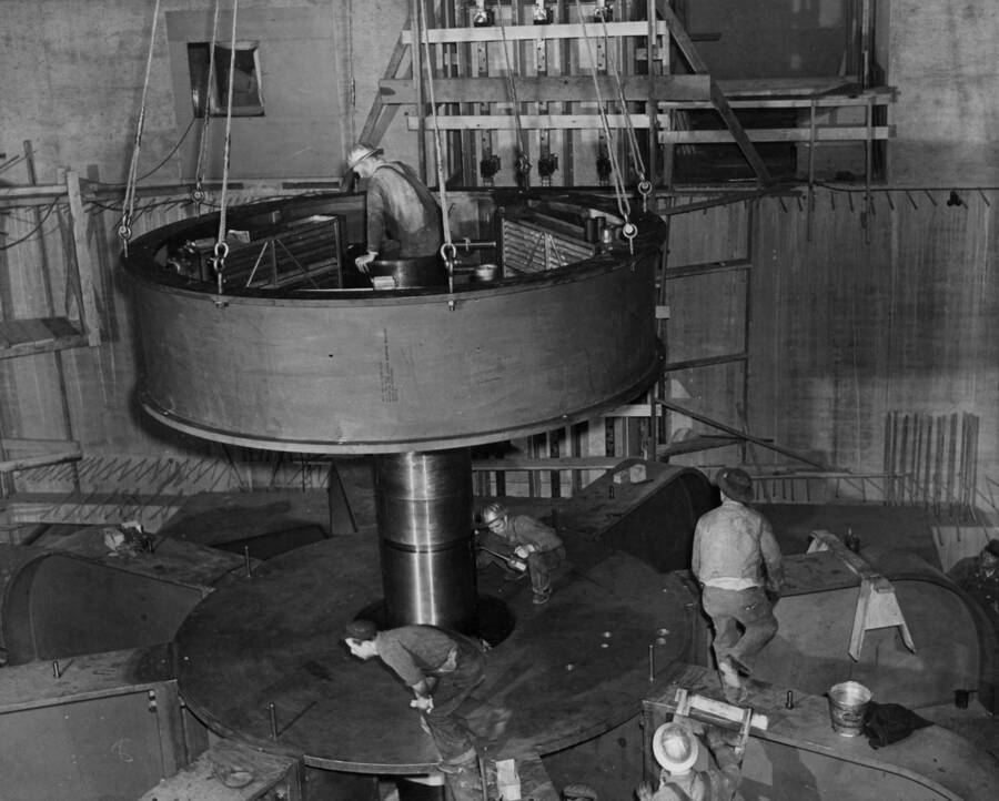 Part of the assembly of thrust bearing for generator Shasta L-8 being lowered into position