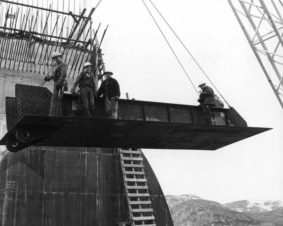 Men stand on girder during drum gate construction