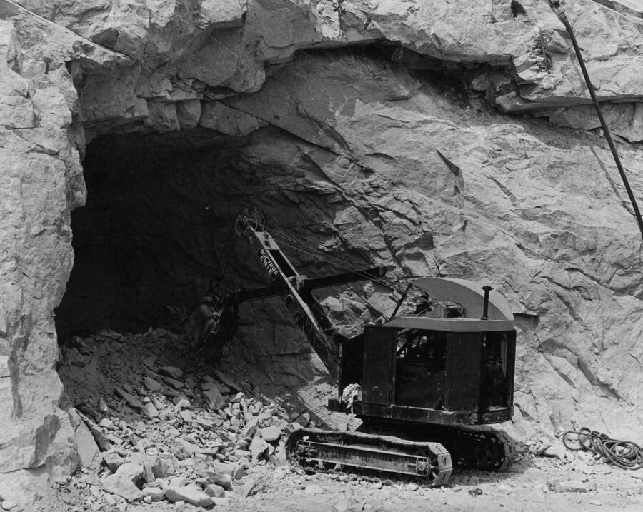 View of heavy machinery digging tunnel into the bank