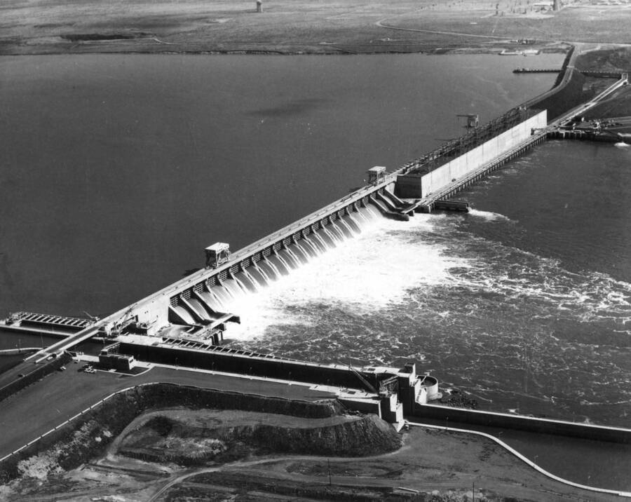 Looking upstream at McNary Lock and Dam, a Walla Walla district, U.S. Army, Corps of Engineers' project on the Columbia River, showing the 7,300-foot long multipurpose project with its lock, north and south shore fish ladders, spillway bays and powerhouse. The 38,800-acre reservoir stretches behind the dam 61 miles upstream to the Pasco Kennewick, Washington area.