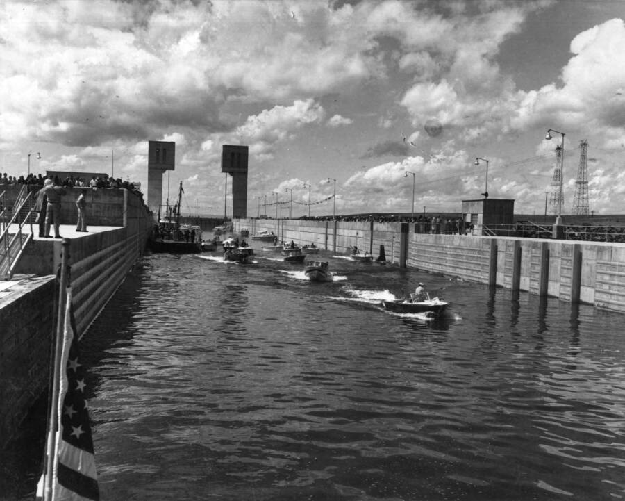 Coast Guard barge and small crafts proceed upstream through the navigation lock for the dedication ceremony on 9 May 1962 at the U.S. Army, Corps of Engineers' Ice Harbor Lock and Dam on the Snake River.