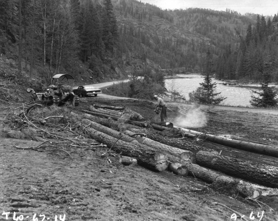 Clearing crews are hard at the task of removing timber from the shore line at the site of the U.S. Army Corps of Engineers Dworshak (Bruces Eddy) Dam three miles upstream from the town of Ahsahka, near the confluence of the North Fork of the Clearwater River and the Clearwater main stem.