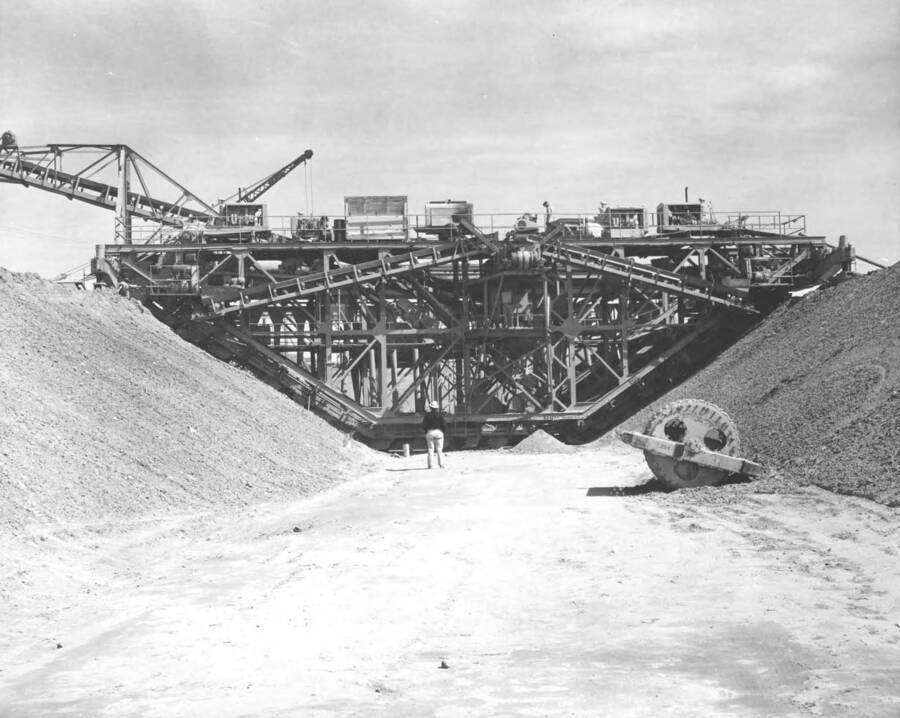 Columbia Basin Project, Irrigation Division, 2nd Section West Canal, Specs. 2541. Canal trimmer, build by Guntert and Zimmerman for the contractor. Lining machine is setting behind the trimmer. Roller in the foreground is a Hyster grid roller used to roll the blanket material on the slopes. Work is being performed by Morrison-Knudsen, Inc. under Schedule 2 of the above Specifications. H.E. Foss, photographer