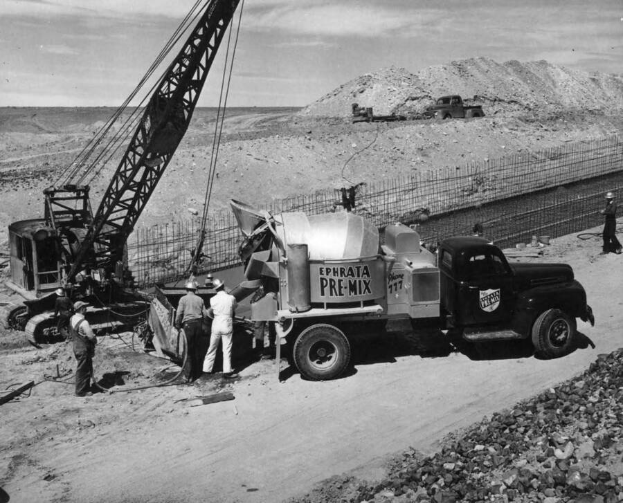 Columbia Basin Project, Irrigation Division, Winchester Wasteway, Specs. 2648. Mixer truck discharging concrete into a 'laydown type' bucket during the first concrete pour in the chute and stilling pool section in the vicinity of Sta. 38+00. The concrete is manufactured in Ephrata, approximately 9 1/2 miles distance. Work is being performed by J. A. Tertling and Sons, Inc. under Schedule 2 of above Specifications. H.E. Foss, photographer