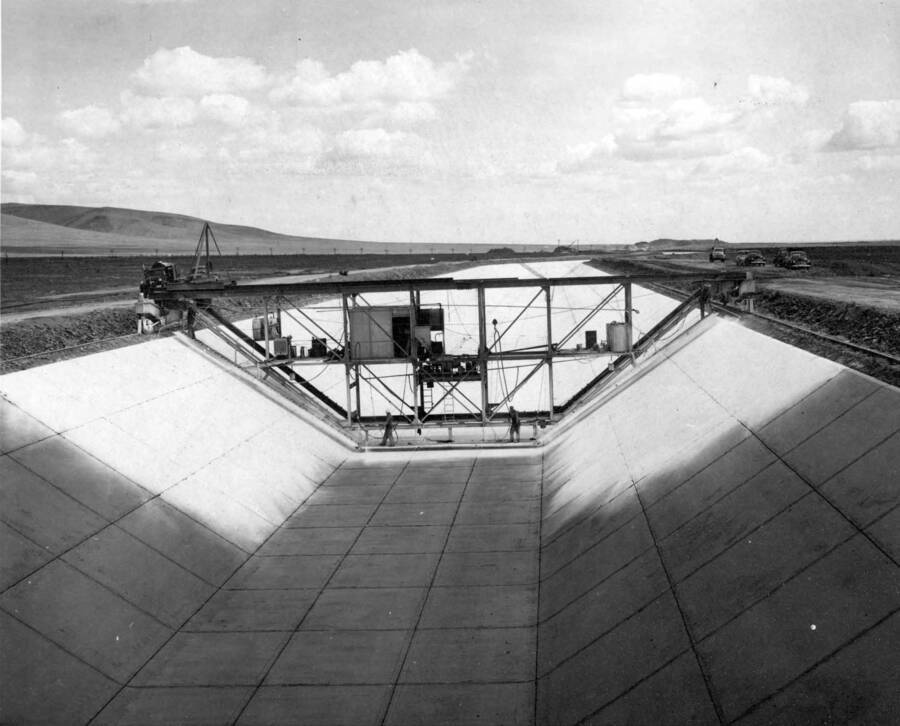 Columbia Basin Project, Irrigation Division, 2nd Section West Canal, Specs. 2541. View of curing jumbo and completed lining from the finishing jumbo. Four workmen are applying white pigmented curing compound to the concrete lining. Work is being performed by Morrison-Knudsen, Inc. under Schedule 2 of above Specifications. H.E. Foss, photographer.