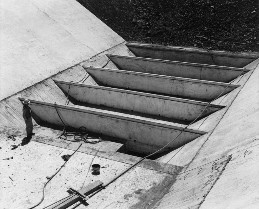 Columbia Basin Project, Irrigation Division, Soap Lake Siphon, Specs 2411. This photograph shows the gravel trap sump and the baffles with their drains very clearly. Flow is from upper right to lower left of the picture. The iron ladder steps for getting in and out of the open transition are shown in the lower right corner of the picture. They are at the beginning of the transition and a similar set is installed on the right side of the transition. Work is being performed by Winston-Utah under Schedule I of above Specifications. H. E. Foss, photographer.