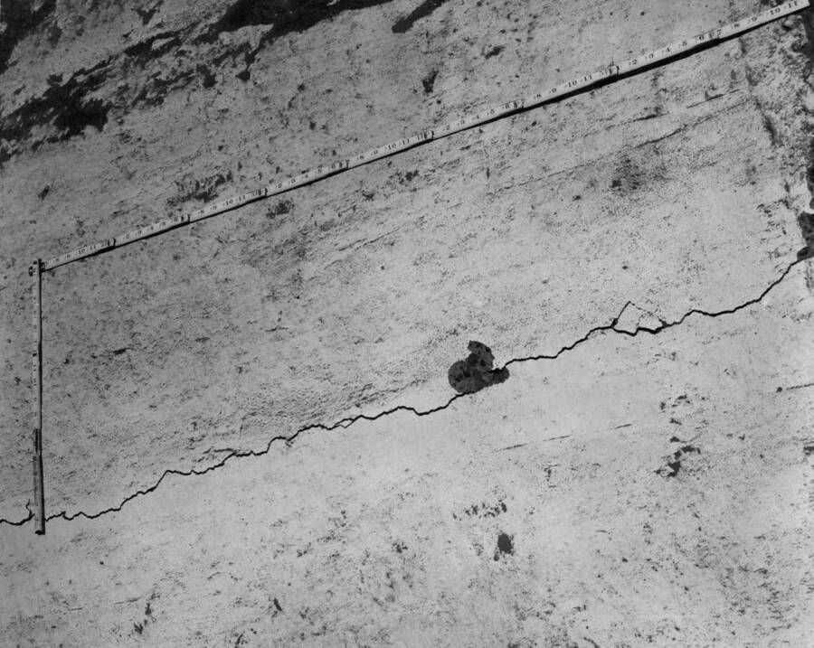 Columbia Basin Project, Irrigation Division, East Low Canal, Specification 1422, Utah Construction Co. and Winston Bros., Contractors. Cracking of an experimental section of the 4 1/2 inch reinforced concrete canal lining which was placed without transverse grooves for approximately 1400 linear feet. These cracks, which vary in width from hairline to 1/4 inch, appear from 50 to 75 foot intervals and extend transversely across the canal almost at exact right angles to the centerline. Note the fracturing of the concrete adjacent to the cracks. The lining was laid during the first week of June, the cracks were first laid during the latter part of July. H.E. Foss, photographer.