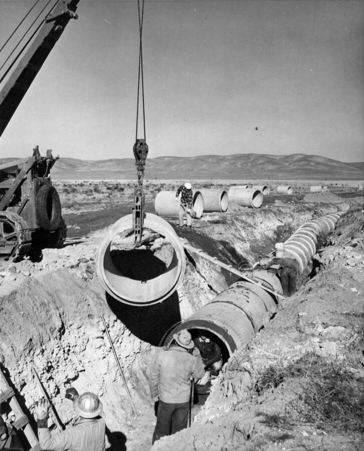 Columbia Basin Project, Irrigation Division, W-3 Laterals, Specs. 2880. W-25 Lateral Station 11+84.50 State Highway #7 crossing. Workman installing 43' Class 'D' pipe. Work is being performed by J.A. Terteling and Sons, Inc. under Schedule 1 of above Specifications.