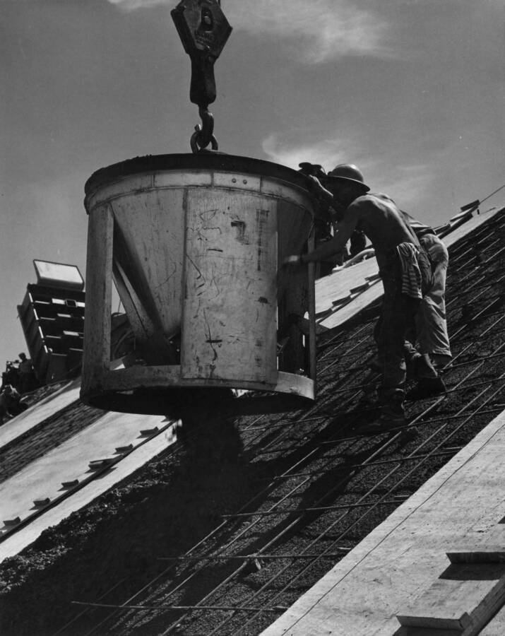 Columbia Basin Project, Irrigation Division, West Canal. Spec. # 1286--Utah construction Co. and Winston Bros. Co. Contractor. Close up view of concrete bucket used in placing of concrete in canal lining in Section 3. Immediately after concrete is dumped from the bucket the surface is leveled with a mechanical screed. A. W. Bauman, photographer.