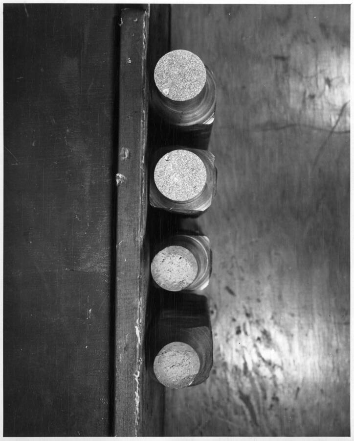 Columbia Basin Project, Irrigation Division, Concrete Laboratory, Ephrata, Washington. View shows fracture area of reinforcing steel specimens tested in laboratory tensile machine. The two-inch square butt-welded specimens, machined to 1 1/2 inches diameter before testing, due to limited capacity of tensile machine, show breaks both in weld and outside weld. Note slag pocket in specimens at left. Specimens on right broke outside weld and reduced end area was caused by necking of bar at break. H.E. Foss, photographer