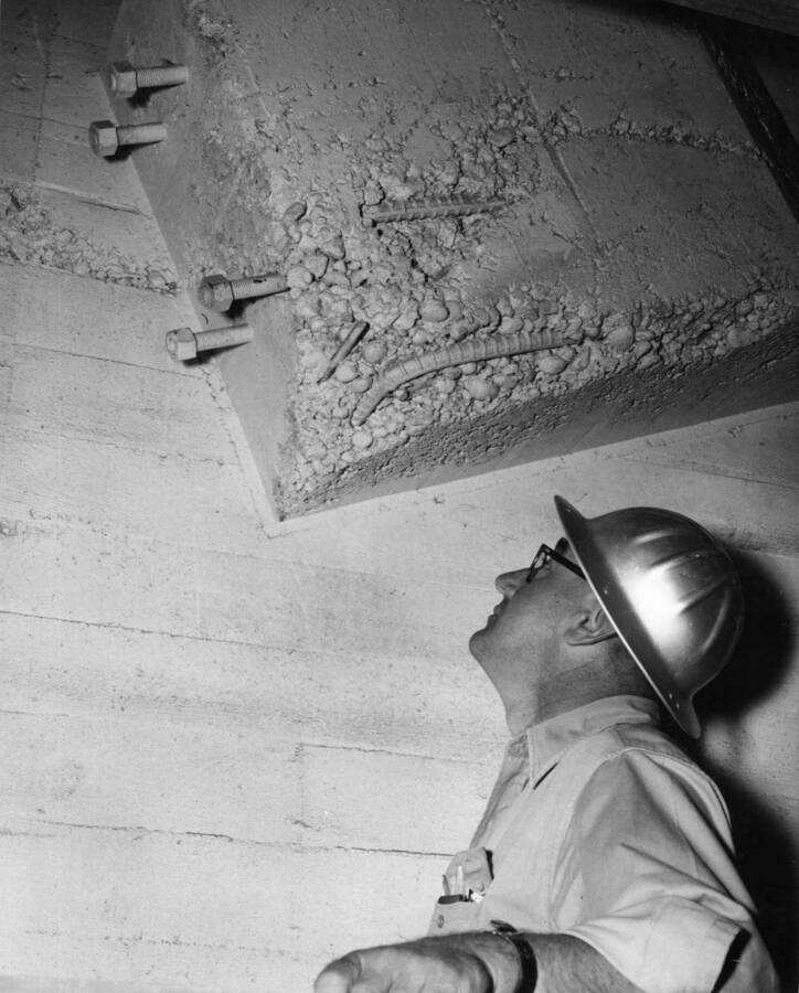 Columbia Basin Project, Irrigation Division, 3rd Section East Low Canal and Weber Wasteway Turnout Structure, Specifications No. 2879. Gate support showing rock pocket and exposed reinforcing steel prior to chipping. Inadequate vibration has resulted in numerous concrete repairs to be necessary in this structure. Concrete placed in subsequent structures have been free from rock pockets as more attention is given to correct placing methods. Work performed by Western Contracting Corporation. H.E. Foss, photographer.