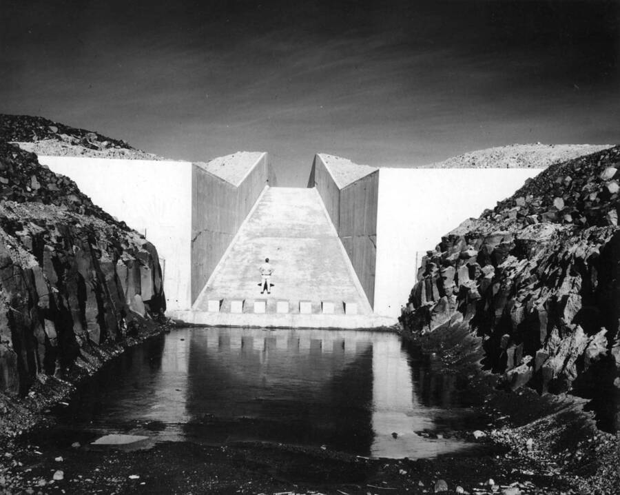 Columbia Basin Project, Irrigation Division, Third Section, West Canal, Specification 2844, Schedule 3. View looking upstream from invert of stilling pool at Station 2044+50 West Canal approximately, showing end of concrete chute at Station 2043+20. The stilling pool was excavated from a columnar basalt rock formation. Minnis and Schilling--Contractor. H.E. Foss, photographer