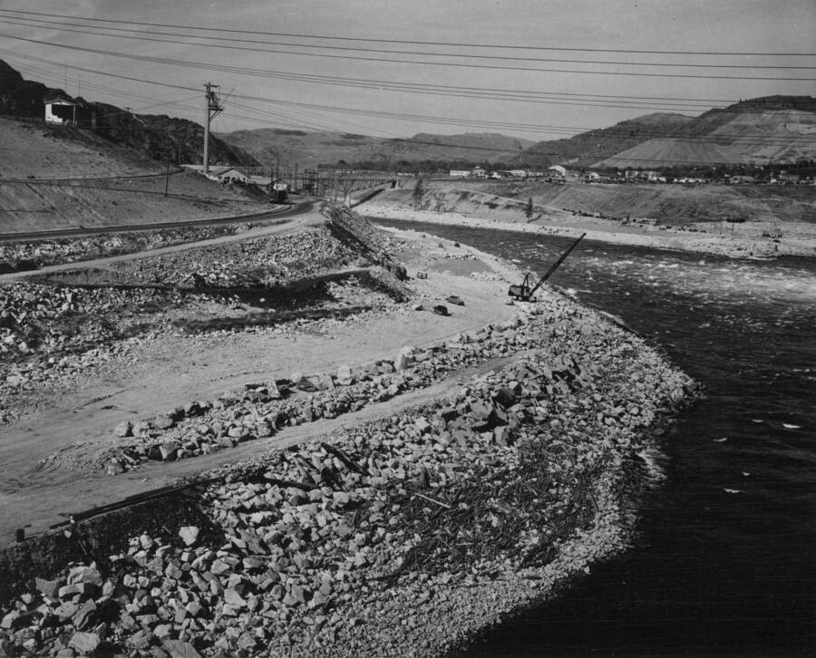 Showing general area of section 'A' for placement of granite armor rock along the left bank of the Columbia River below Grand Coulee Dam. The section extends from the crane upstream to a point opposite the large concrete blocks, showing on the riprap slope a little to the right of the center of the picture and just above the debris. These concrete blocks are from the excavation of the Shasta generating units and withstood the flood waters of 1948. This work is performed by J.A.Terteling and Sons, Inc., under provisions of negotiated contract I2r-18456, Specifications 2636