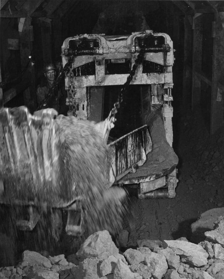 Columbia Basin Project, Irrigation Division, Bacon Tunnel. Photo shows "mucker" working inside the tunnel, T.E. Connolly Company, Inc., contractor. Location approx. 5 miles south of Coulee City, Wash.