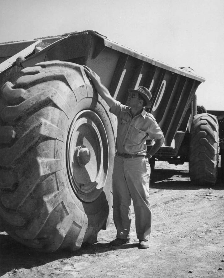 Columbia Basin Project, Irrigation Division, Potholes Dam. Right rear view of contractors 24 cubic yard bottom dump Euclid. Note size of tires. Man in picture is six feet tall. Despite its size and weight, this piece of equipment has excellent floatation and traction.