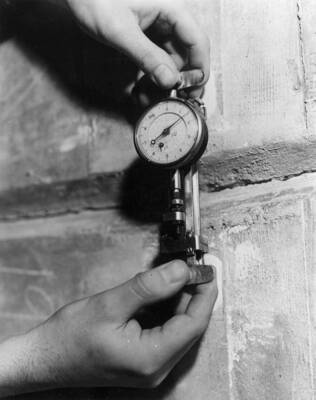 Close up view of a man gauging offsets between concrete units