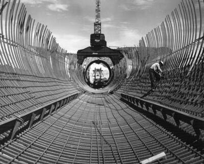 Columbia Basin Project, Irrigation Division, Soap Lake Siphon, Specifications No. 2411--Utah Construction Co. and Winston Bros. Co., Contractor. This longitudinal view shows the outer curtain of re-steel. The liner curtain and 'liner' support staubs and channel iron. The 'liner' placing gantry--a liner section and the stiffener ring replacement jigs. H.E. Foss, photographer
