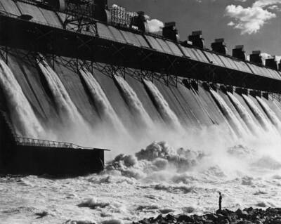 View of the outlet works near the base of the dam. A man is standing in foreground for scale.