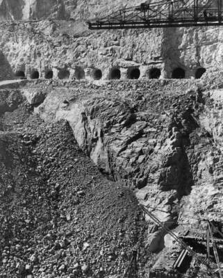 View of men working on tunnels cut into the bank