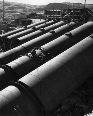 Specifications 2329. Contractor: Morrison-Knudsen Company, Inc., and Peter Kiewit Sons' Co. View of the 12-foot diameter pump-discharge pipes P-1 to P-6 showing their entrance into the outlet structure.