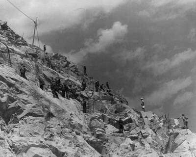 Men remove rock on steeper section of the river bank.