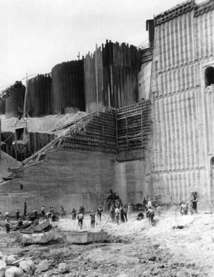 Columbia Basin Project, Grand Coulee Dam. Bedrock in the old river channel, showing the natural water-worn rock surface as it is found under a bed of clay and boulders left in the canyon during the last ice age, and the operation of removing surface rock to provide for a firm and watertight connection between bedrock and the dam.