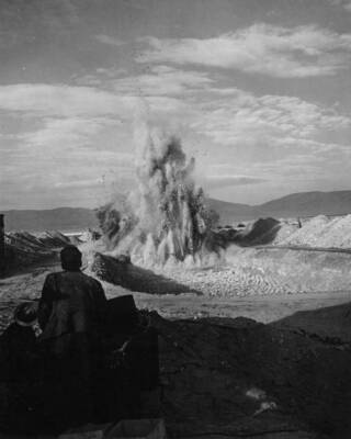 Columbia Basin Project, Irrigation division, Specifications No. 2648, Winchester Wasteway, Earthwork and Structures Station 1/28.67 to station 964/00. Contractor: J.A. Tertling and Sons, Inc. Blasting in the vicinity of Station 7/00 in the chute section. The picture is taken, looking north, from the highway 8 miles east of Quincy, Wash. Harold Foss, photographer.