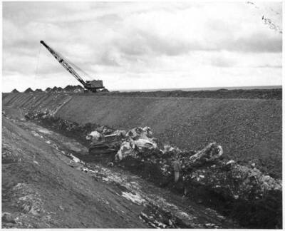 Columbia Basin Project, Irrigation Division, 2nd Section West Canal, Specs. 2541. Bucyrus-Erie 51-B dragline and dozer removing snow from the canal at about station 1155. Note the size of the blocks of snow as compared with the man and the dozer in the canal. Work is being performed by Morrison-Knudsen, Inc. under Schedule 2 of above specifications. H.E. Foss, photographer