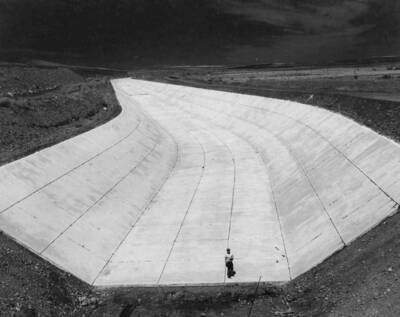 Columbia Basin Project, Irrigation Division, 2nd Section West Canal, Specs. 2541. Looking upstream at the completed lining from the Baily Bridge at Ephrata. Work is being performed by Morrison-Knudsen, Inc. under Schedule 1 of above Specifications. H.E. Foss, photographer