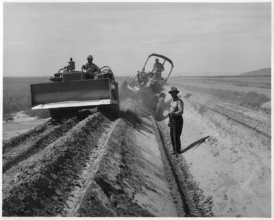 View showing motor grader excavating and rough trimming for asphaltic lining on Pasco Pump Lateral System at PP-7.7 Sta. 13 (2c section). This feature under construction by J.A. Tertling and Sons, Inc., 12 to 15 miles northwest of Pasco, Washington, Specifications 1230.