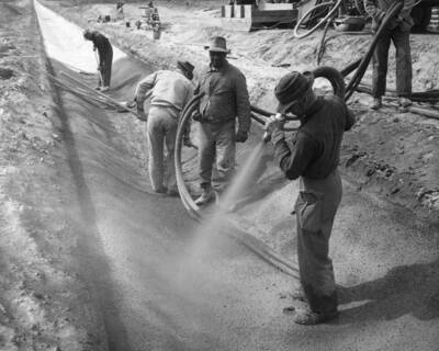 View showing equipment and placing of 1 1/2 inch thick pneumatically applied mortar lining on Pasco Pump lateral system PP-6.0-0.5 lateral vicinity sta. 4+00. This section is under construction 10 to 15 miles northwest of Pasco, Wash. By J.A. Tertling and Sons, Inc., specifications 1230,
