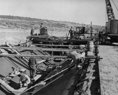 View looking downstream showing slip form used in placing 3-inch concrete lining in Pasco Pump Lateral System, PPL Sta. 46+50, 10 to 15 miles northwest of Pasco, Washington, which is under construction by J.A. Terteling and Sons, Inc., Specifications 1230