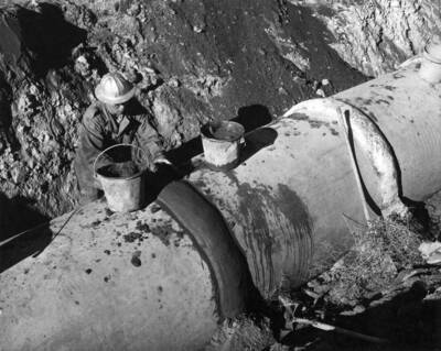 Columbia Basin Project, Irrigation Division, W-3 Laterals, Specs. 2880. W-25 Lateral Station 11+84.50 State Highway #7 crossing. Workman installing 43' Class 'D' pipe. Work is being performed by J.A. Terteling and Sons, Inc. under Schedule 1 of above Specifications.