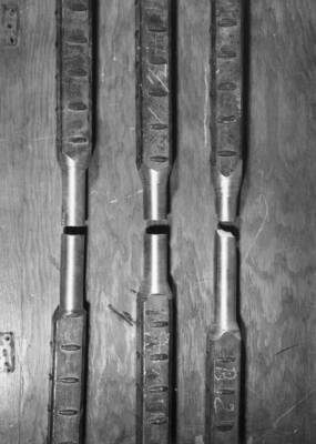 Columbia Basin Project--Irrigation Division--Concrete Laboratory, Ephrata, Washington. Photo illustrates method used to test efficiency of two-inch square butt-welded reinforcing steep specimens being placed on Soap Lake Siphon contract. Test specimens have been turned down to 1 1/2 inch diameter in vicinity of weld before testing, due to limited capacity of tensile machine. Two specimens shown failed in weld while third broke outside weld. H.E. Foss, photographer.