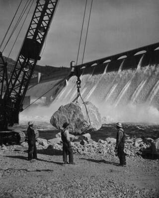 Placing a granite armor rock weighing well over six tons on the left bank of the Columbia River. The rock is from the upriver quarry. This work is being performed by J.A. Terteling and Sons, Inc., under provisions of negotiated contract I2r-18456, Specifications 2636